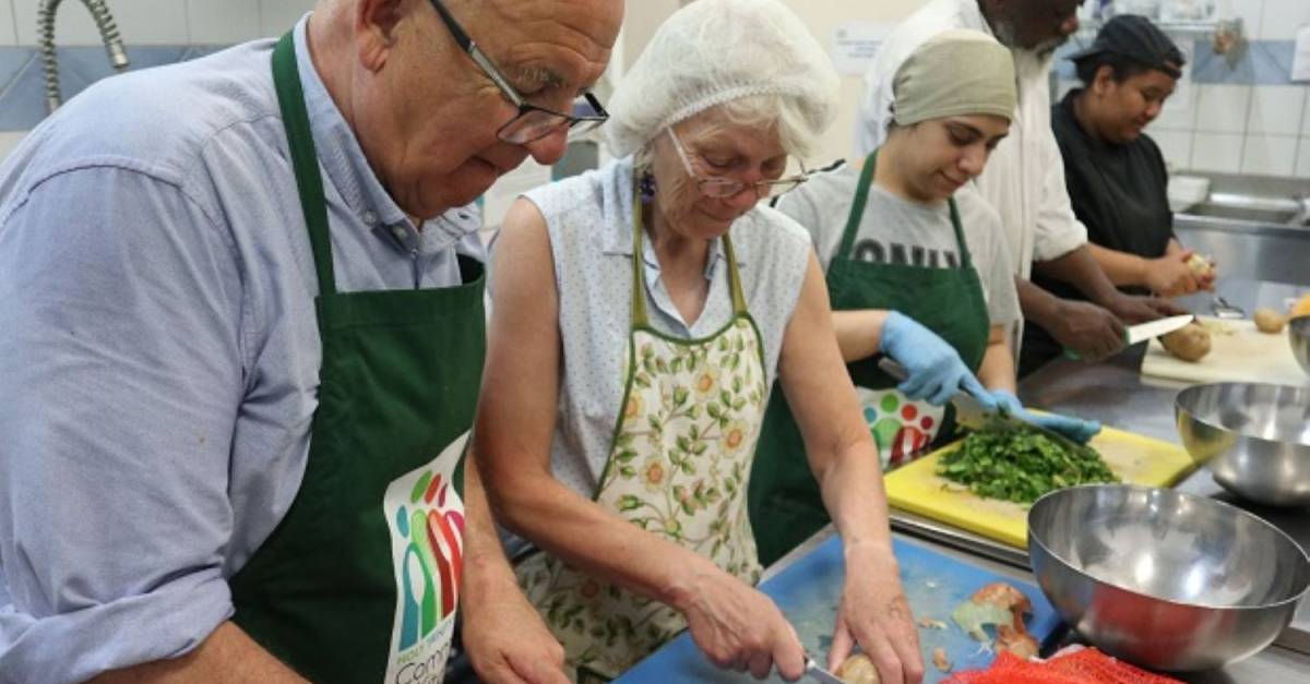 Volunteers preparing food safely in a community kitchen